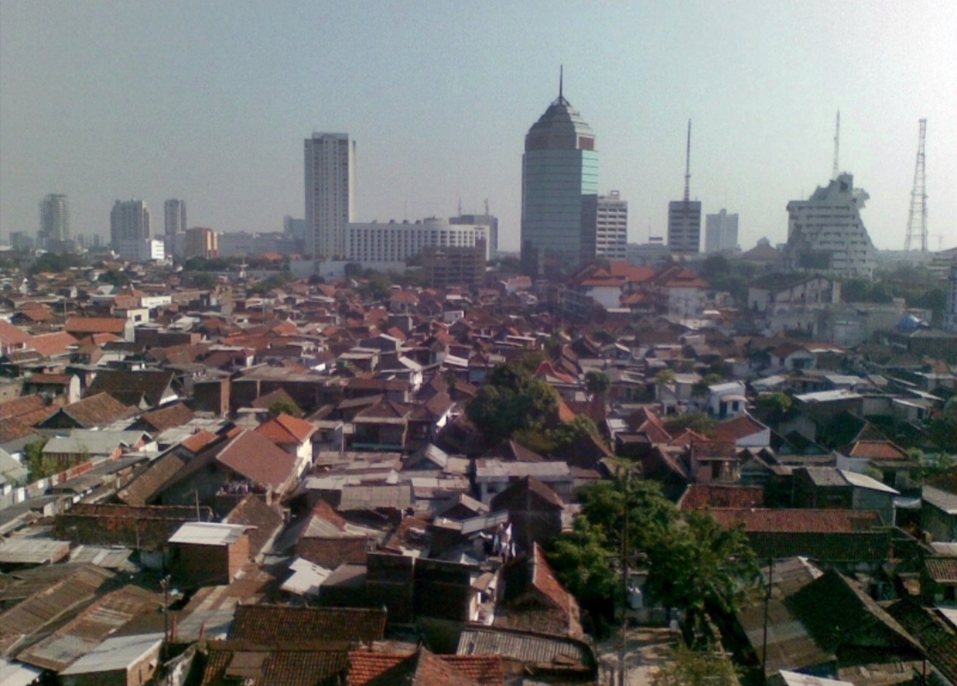 Pemandangan udara Kota Surabaya dengan latar Gedung Balai Kota dan kawasan pemukiman padat.