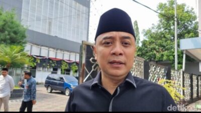 Wali Kota Surabaya Eri Cahyadi mengenakan peci hitam dan kemeja gelap sedang memberikan keterangan pers terkait larangan pembakaran sampah dan isu mikroplastik di Surabaya.
