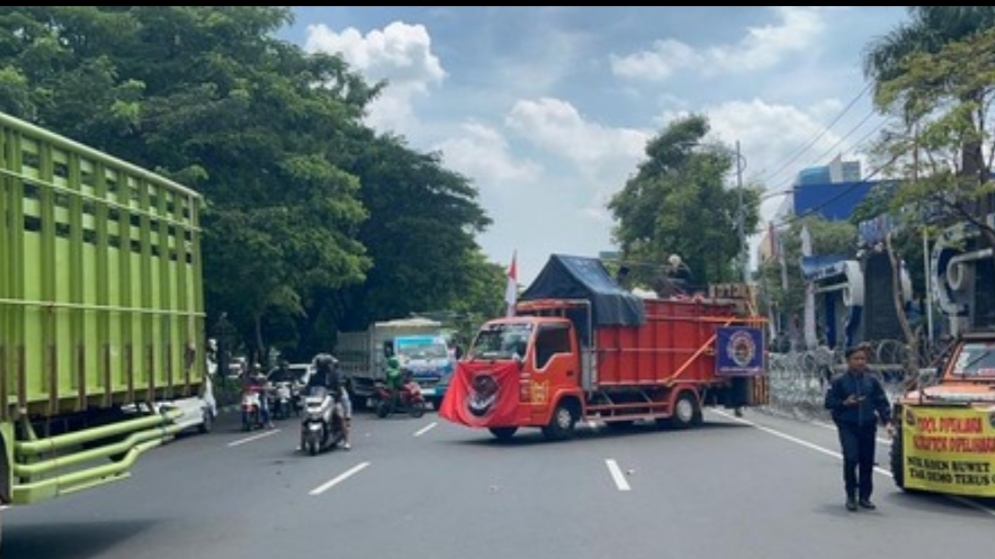 Suasana demonstrasi sopir truk ODOL yang memarkirkan kendaraan hingga menutup badan jalan Frontage Ahmad Yani Surabaya di depan kantor Dishub Jatim