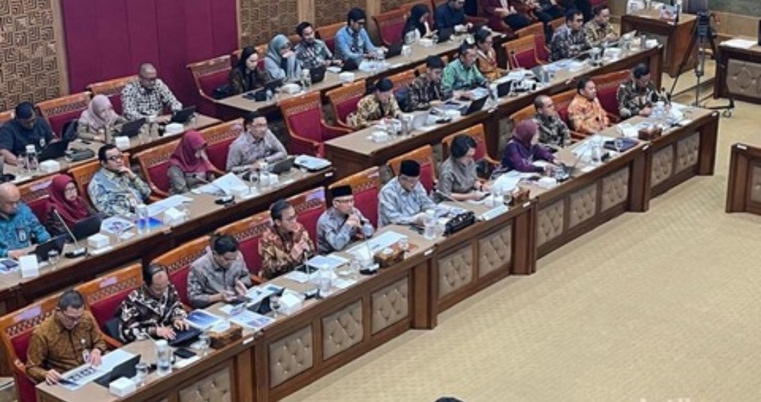 Sejumlah anggota Komisi X DPR dan jajaran Kemendikdasmen mengikuti rapat kerja di ruang rapat parlemen, dengan dokumen dan laptop terhampar di meja.