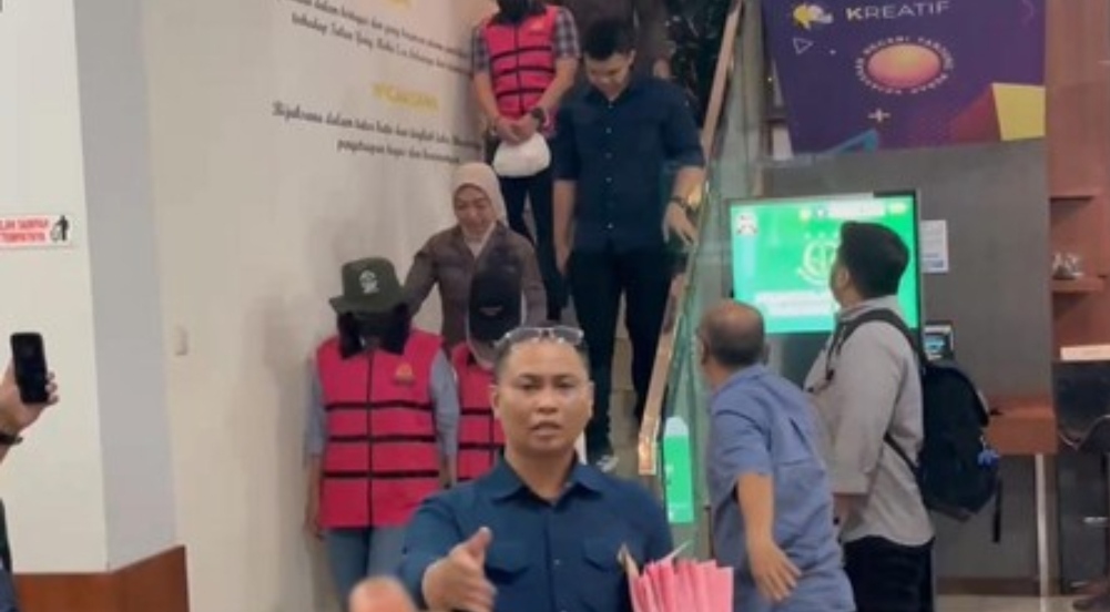 Sejumlah tersangka dugaan korupsi Pelindo dan APBS mengenakan rompi tahanan berwarna merah muda saat digiring petugas Kejaksaan menuruni tangga di kantor Kejari Tanjung Perak, Surabaya.