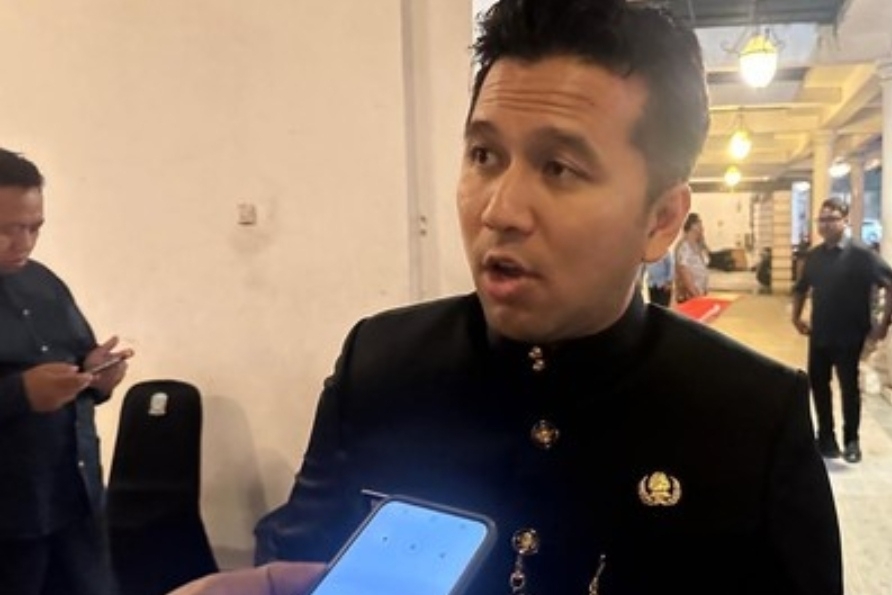 Wakil Gubernur Jawa Timur Emil Dardak mengenakan pakaian dinas hitam dengan kancing emas sedang berbicara saat diwawancarai oleh seseorang yang memegang ponsel untuk merekam di sebuah koridor gedung.