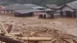 Banjir bandang merendam permukiman warga dengan material kayu dan puing berserakan di Sumatera Utara, 27 November 2025.