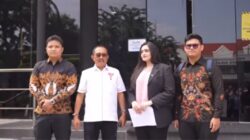 Wakil Walikota Surabaya Armuji berbaju putih berdiri bersama tiga orang tim hukum di depan pintu kaca gedung Polrestabes Surabaya.