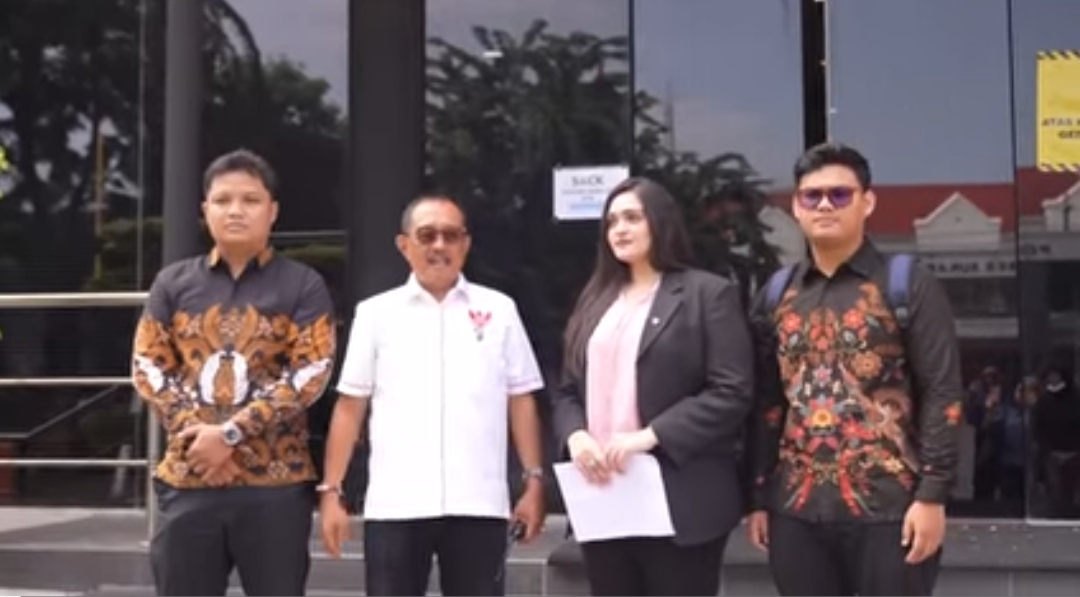 Wakil Walikota Surabaya Armuji berbaju putih berdiri bersama tiga orang tim hukum di depan pintu kaca gedung Polrestabes Surabaya.