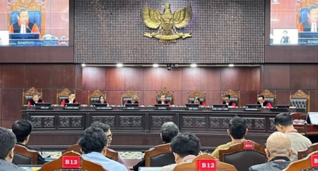 Suasana ruang sidang Mahkamah Konstitusi dengan deretan hakim duduk di meja persidangan dan peserta sidang terlihat dari belakang kursi pengunjung.