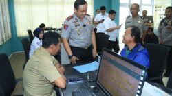 Kapolres Gresik inspeksi pelayanan publik sambil berbincang santai dengan warga di meja layanan.