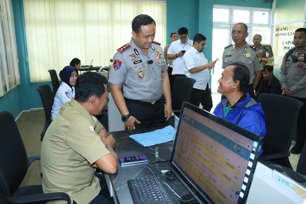 Kapolres Gresik inspeksi pelayanan publik sambil berbincang santai dengan warga di meja layanan.