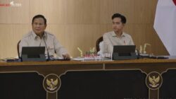 Presiden Prabowo Subianto memimpin rapat bersama jajaran pemerintah di ruang pertemuan resmi, dengan lambang Garuda Pancasila terlihat di bagian depan meja.