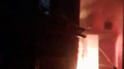 Petugas pemadam kebakaran menyemprotkan air ke api yang membakar rumah warga di Simo Gunung, Surabaya. Api terlihat menyala dari dalam bangunan. Lokasi berada di gang sempit dengan jarak rumah berdekatan. Kejadian berlangsung pada dini hari. Proses pemadaman dilakukan untuk mencegah api meluas.