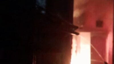 Petugas pemadam kebakaran menyemprotkan air ke api yang membakar rumah warga di Simo Gunung, Surabaya. Api terlihat menyala dari dalam bangunan. Lokasi berada di gang sempit dengan jarak rumah berdekatan. Kejadian berlangsung pada dini hari. Proses pemadaman dilakukan untuk mencegah api meluas.