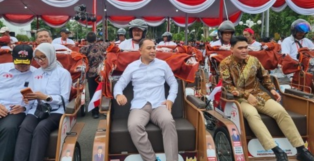 wali kota surabaya berada di becak listrik saat acara penyerahan bantuan pemerintah kepada pemerintah kota di surabaya