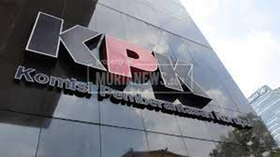 Seorang pejabat KPK berbicara di depan mikrofon dengan logo lembaga di belakangnya