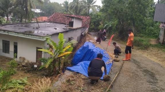 Petugas menangani longsor di Pamekasan dekat permukiman warga