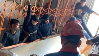 Petugas melakukan evakuasi enam karyawan ruko yang terjepit teralis dan lembaran akrilik dalam insiden di Jalan Semarang, Surabaya, dengan pengamanan tali dan penopang material saat proses penyelamatan berlangsung.