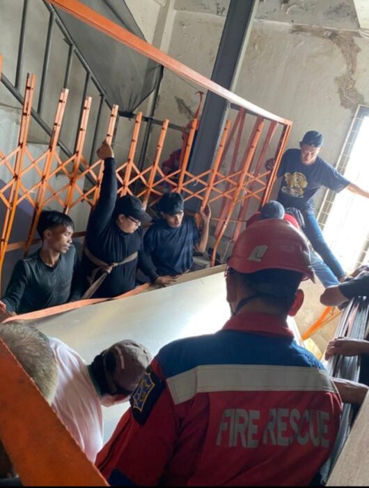Petugas melakukan evakuasi enam karyawan ruko yang terjepit teralis dan lembaran akrilik dalam insiden di Jalan Semarang, Surabaya, dengan pengamanan tali dan penopang material saat proses penyelamatan berlangsung.